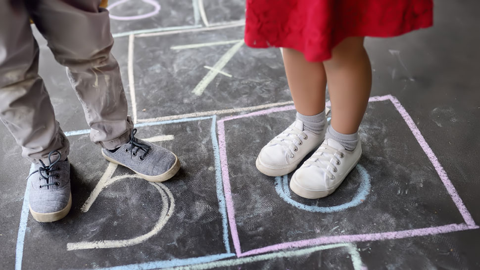 Kinder spielen auf der Straße mit Kreidefarben: Die Rechte und Pflichten von Kindern in Deutschland sind vielfältig.