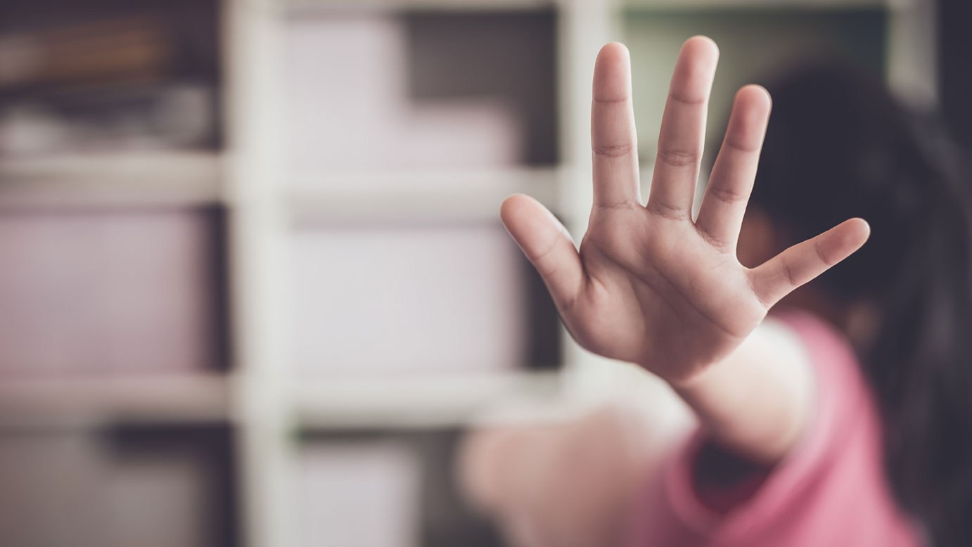 Kind verdeckt sich Gesicht mit Hand: Es wurde Opfer von sexuellem Missbrauch und sucht Hilfe.