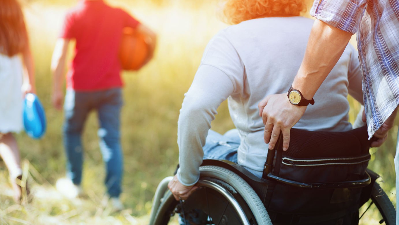 Ein behinderter Mensch im Rollstuhl: Durch ein Behindertentestament behält der Erbe die Erbschaft für sich.