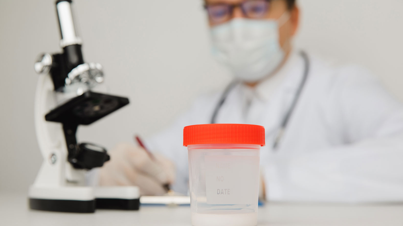 Spermaspender werden: Reproduktionsmediziner analysiert Samenprobe eines Mannes im Labor