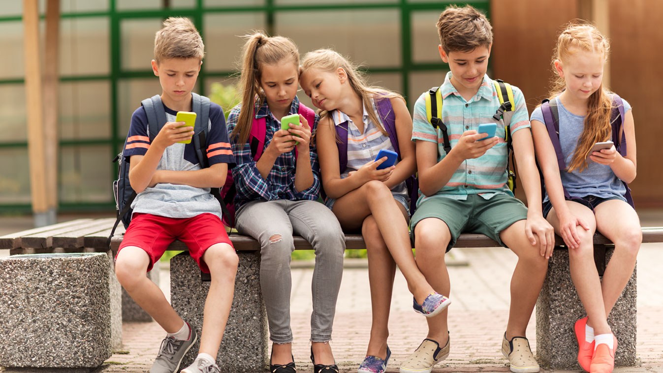 Kinder spielen an ihren Smartphones und schauen Videos: Jugendschutz wird immer wichtiger.