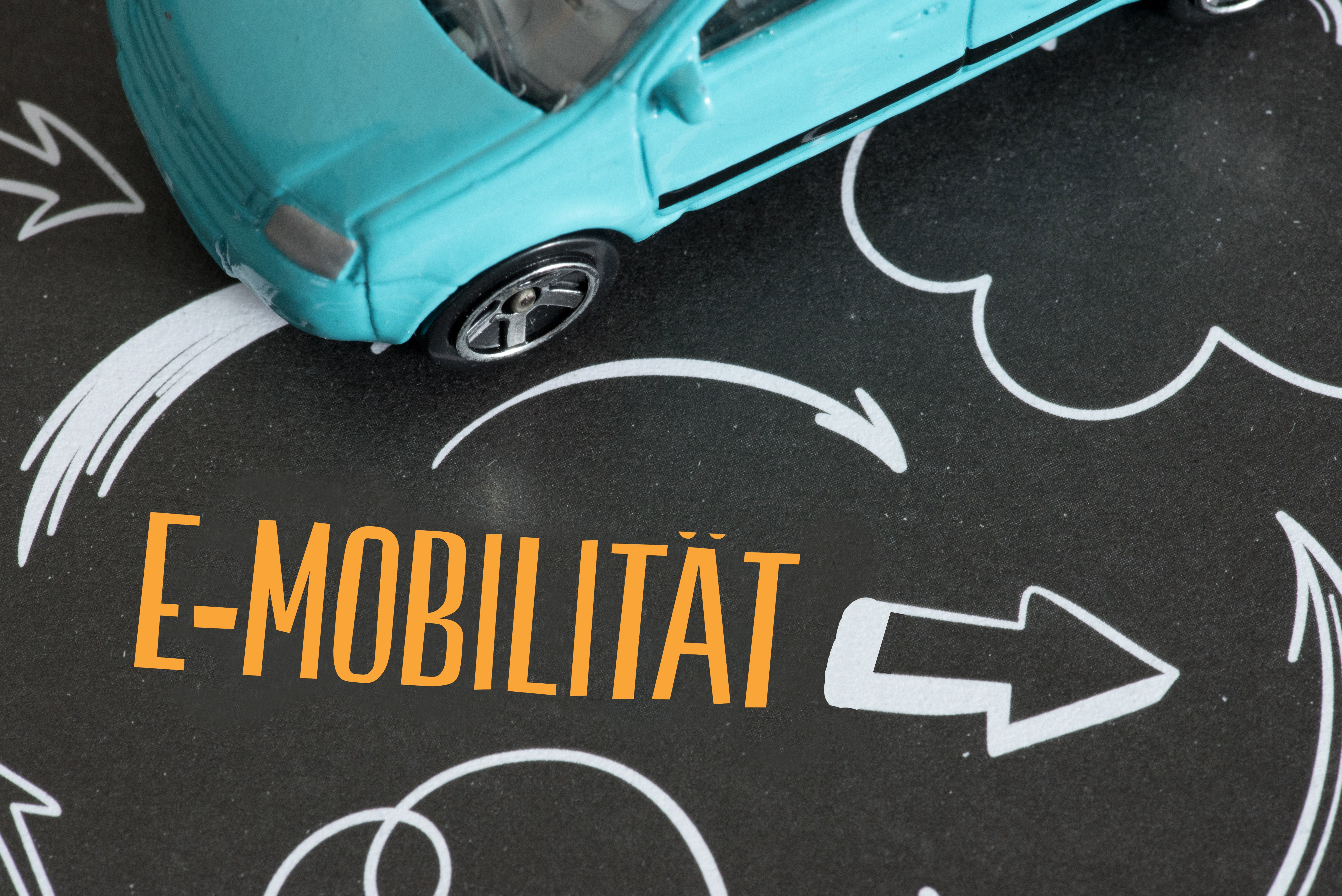 Auto und Pfeil, der auf E-Mobilität hinweist